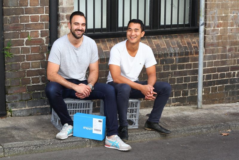 Shippit founders sittinong on crates with shippit parcel