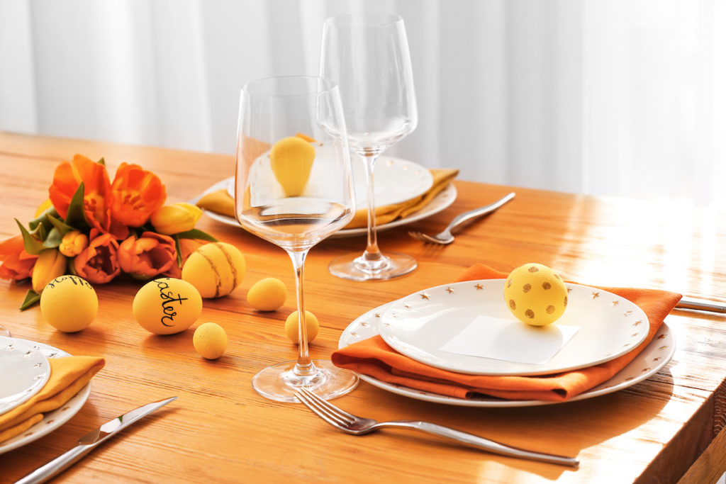 Orange easter table setting. Image by Pixel-Shot via Shutterstock.