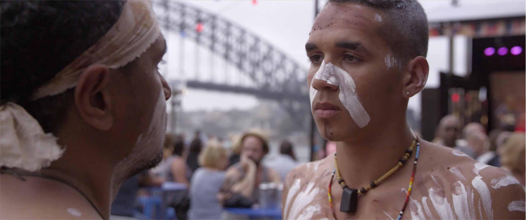 two indigenous kids face off in front of harbour bridge