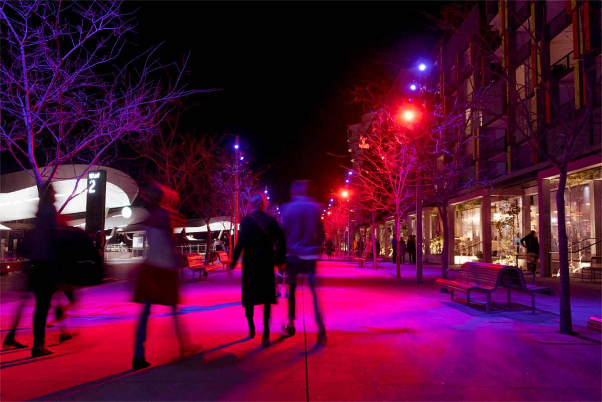 people walking at night with red lights 