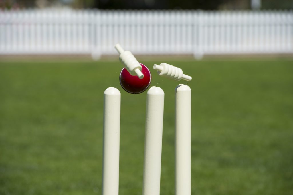 Bails fly from cricket stumps. Image by xshot via Shutterstock.