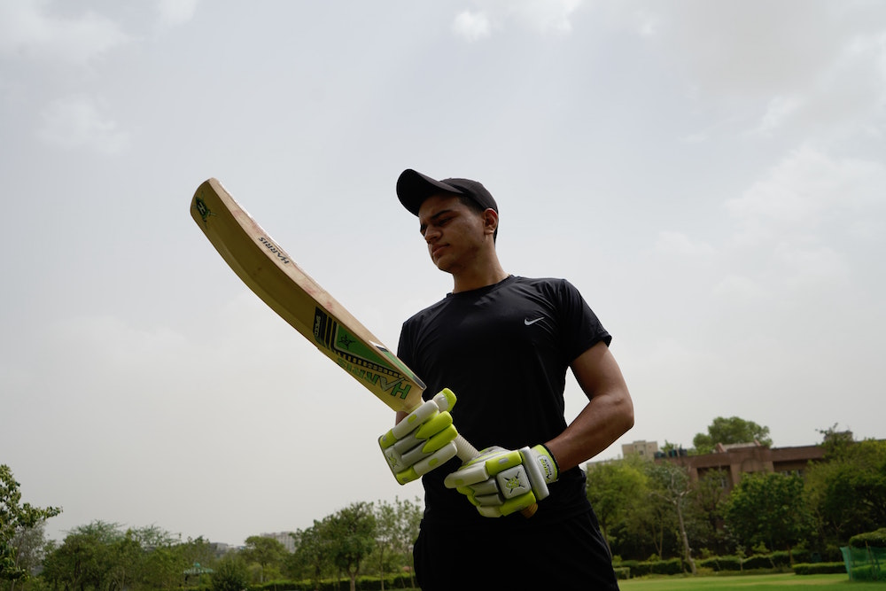 Man holding cricket bat. Image by Yogendra Singh via Unsplash.