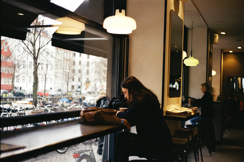 Woman in Cafe in Copenhagen. Image by Dominika Kiraly via Unsplash.