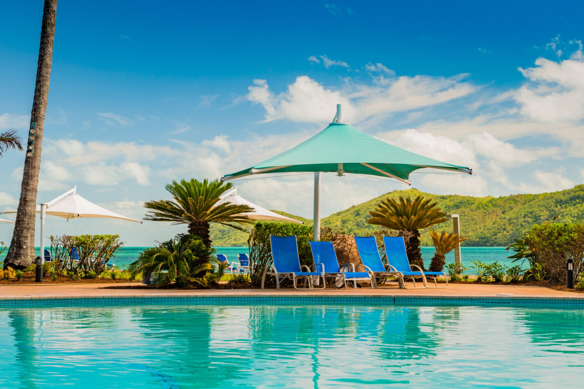 Deck chairs by the pool at Daydream Island Resort, Queensland. Photography by Fotoaray. Image via Shutterstock