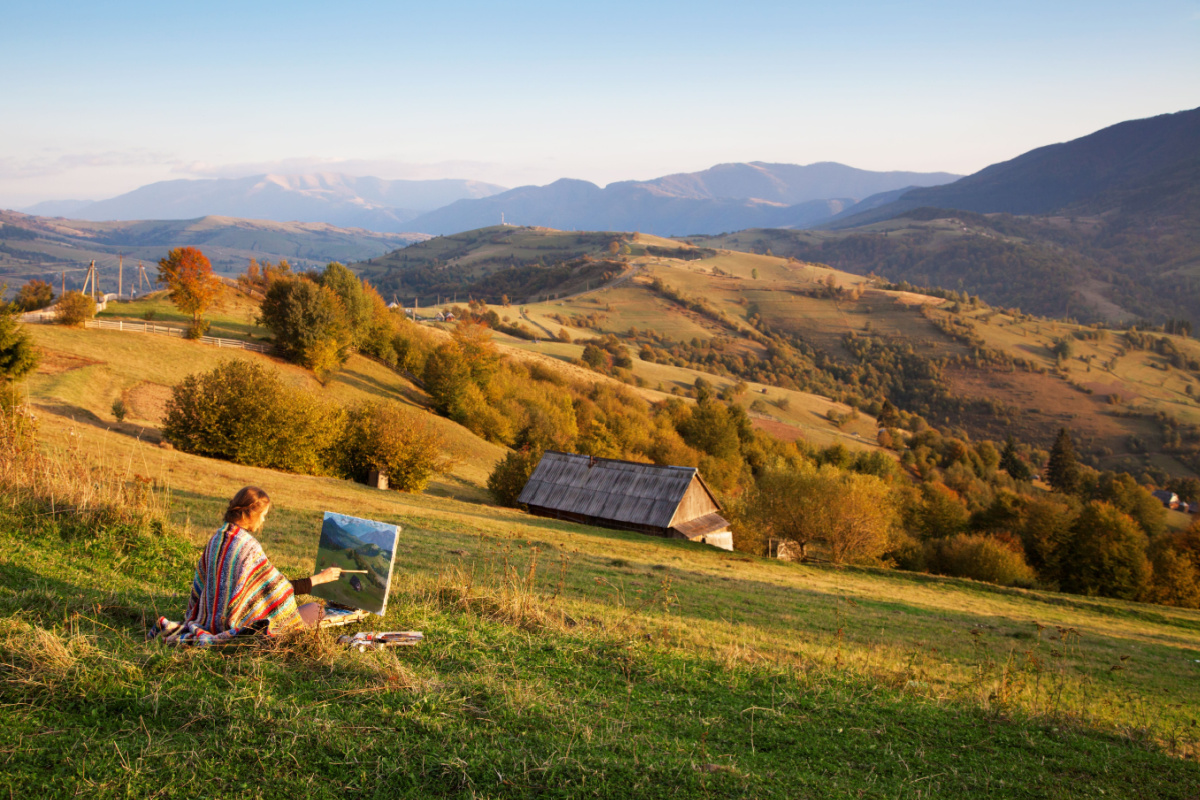 Young artist painting an autumn landscape. Photography by George Dolgikh. Image via Shutterstock