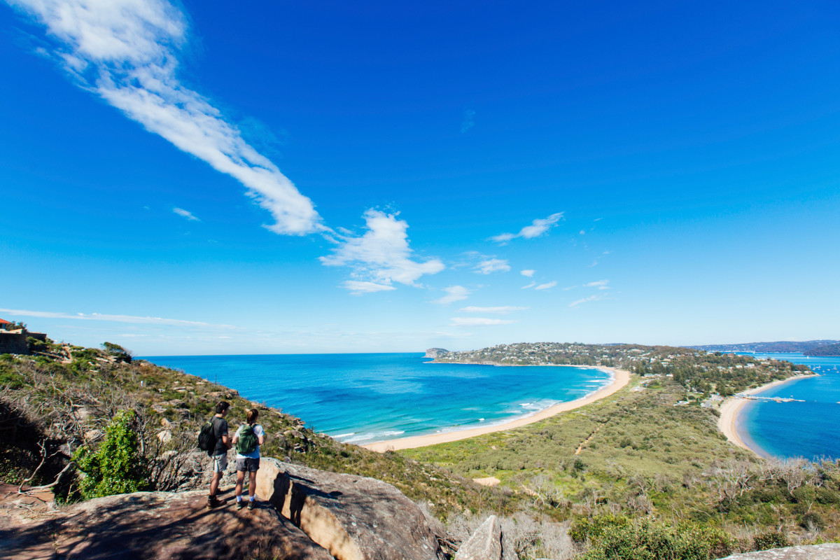 Couple enjoying a scenic coastal hike on the Barrenjoey Lighthouse Walk in Palm Beach, Sydney. Image: Destination NSW