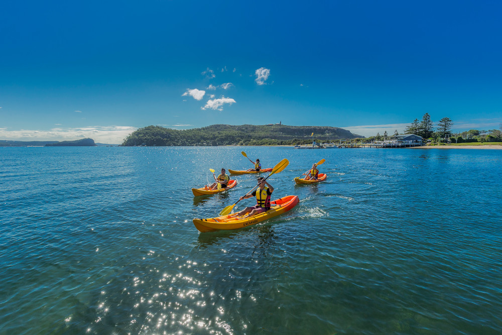 Friends kayaking on Pittwater near Boathouse Restaurant and Palm Beach Lighthouse. Image: Destination NSW