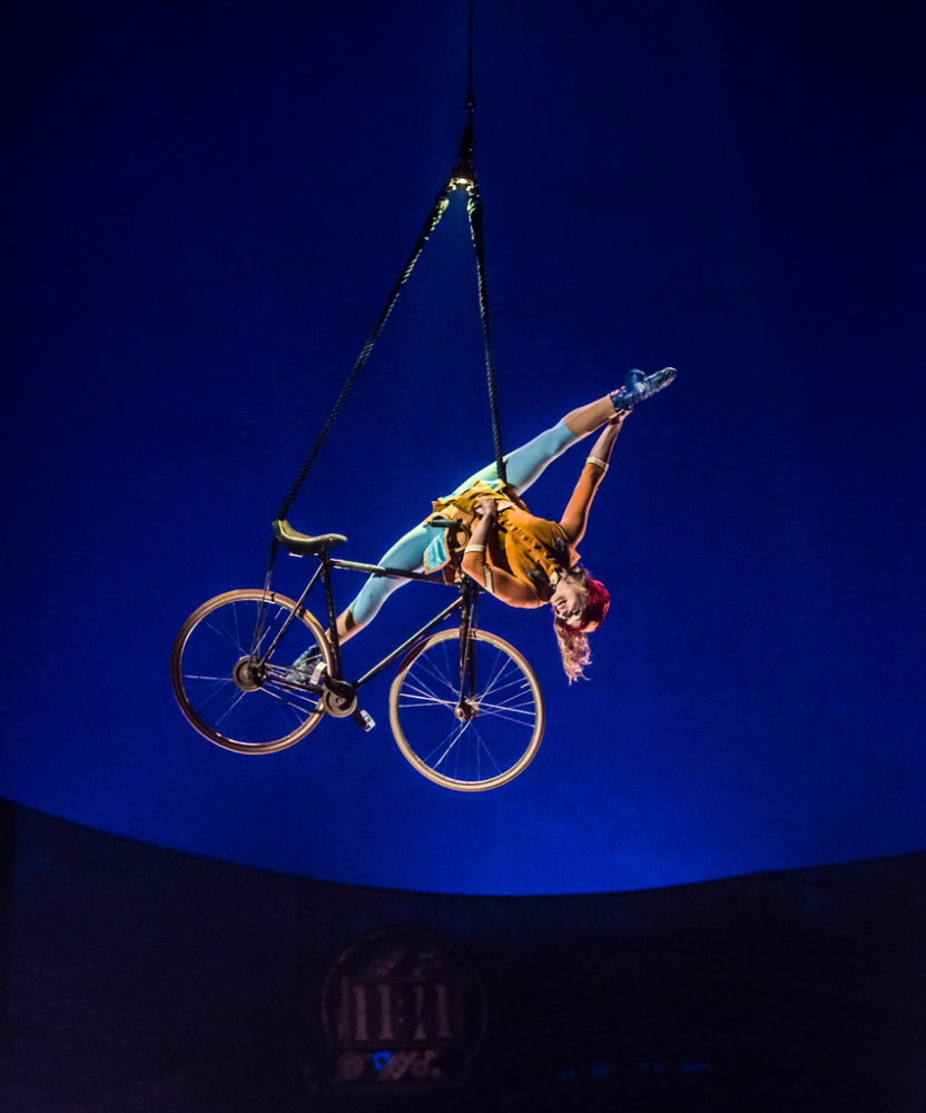 The contorting woman on a bike. Image: Martin Girard / shootstudio.ca Costumes: Philippe Guillotel © 2014 Cirque du Soleil