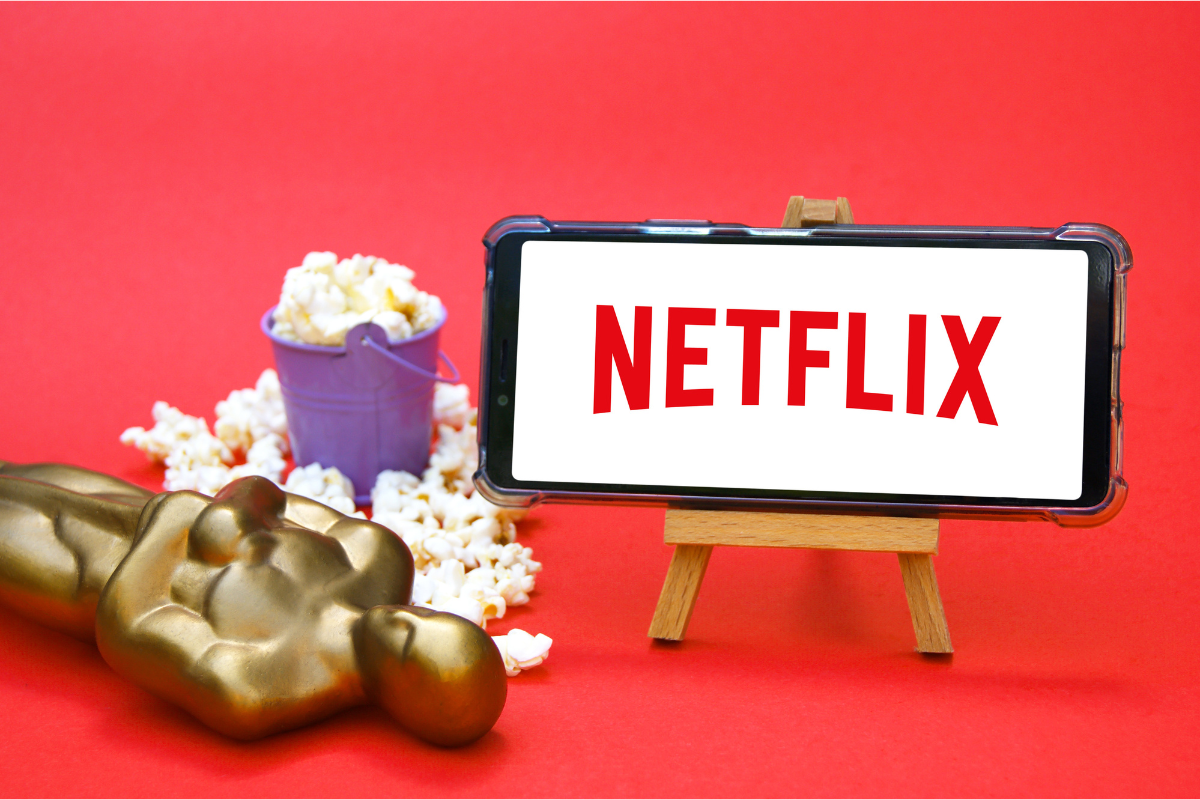 Netflix on phone and Oscar statue. Photography by iama_sing. Image via Shutterstock