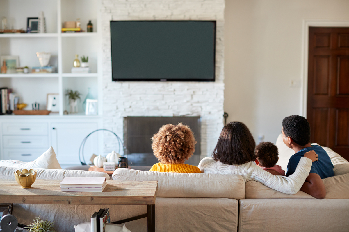 Family watching TV in nice living room seen from behind