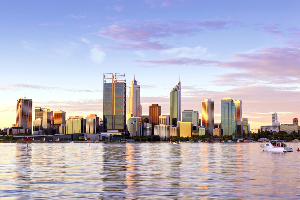 City skyline over Swan River at sunset. Photographed by Robyn Mackenzie. Image via Shutterstock.