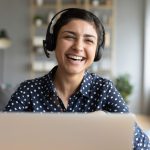 Woman laughing over video chat. Image: fizkes via Shutterstock