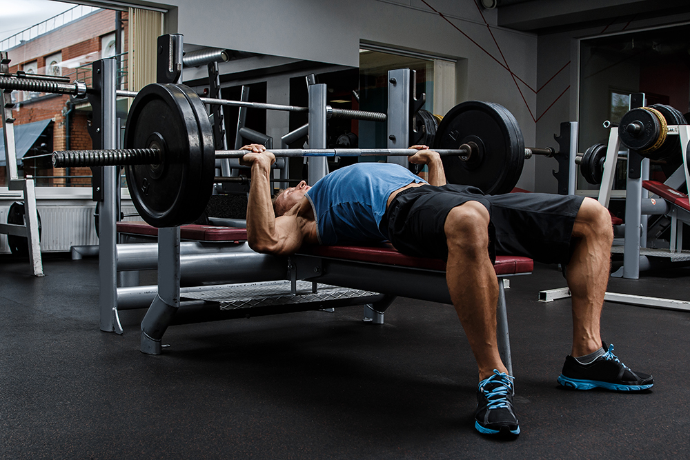 Male athlete executing bench press. Image purchased.