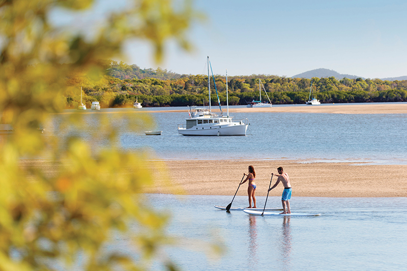 Stand Up Paddle Boarding at 1770. Image via Tourism and Events Queensland