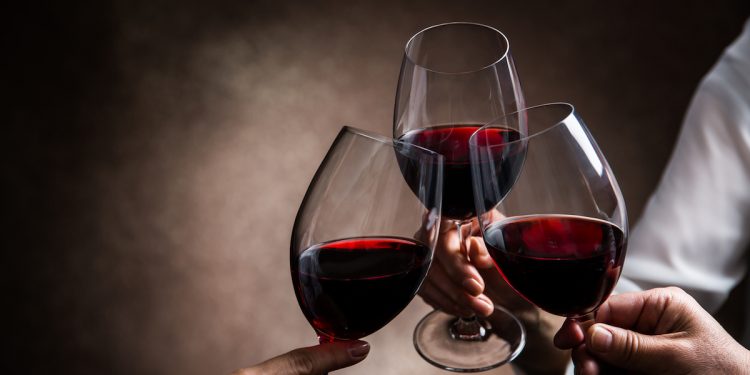 3 red wine glasses toasting. Photographed by taa22. Image via Shutterstock