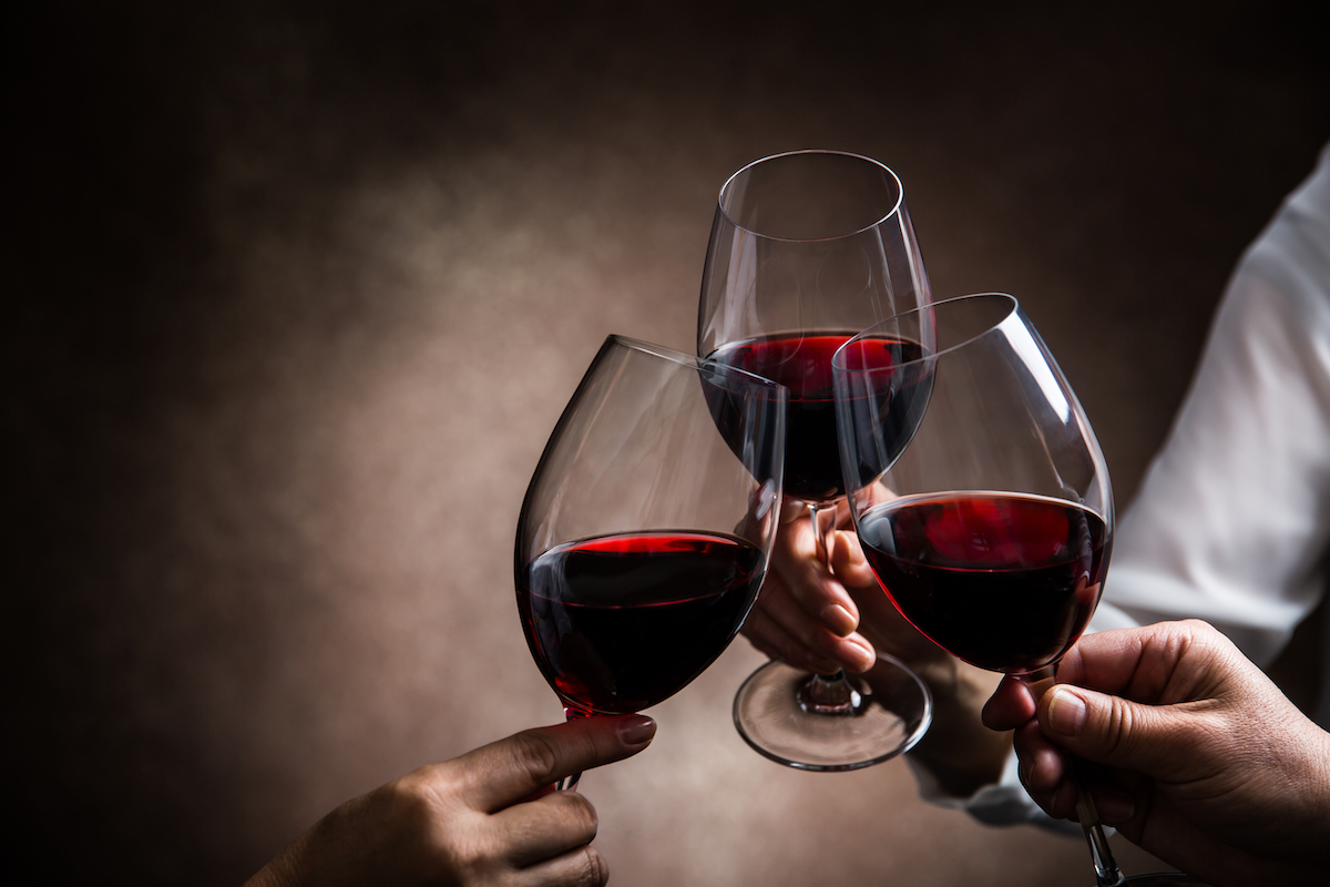 3 red wine glasses toasting. Photographed by taa22. Image via Shutterstock