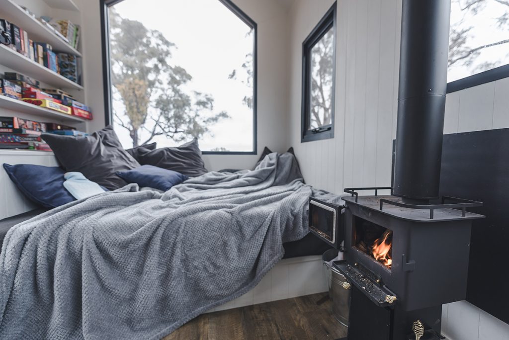 Kindled Tiny Home, New South Wales, bed and fireplace. Image supplied via Kindled