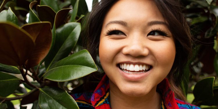 Happy woman among trees. Photographed by Courtney Cook. Image via Unsplash
