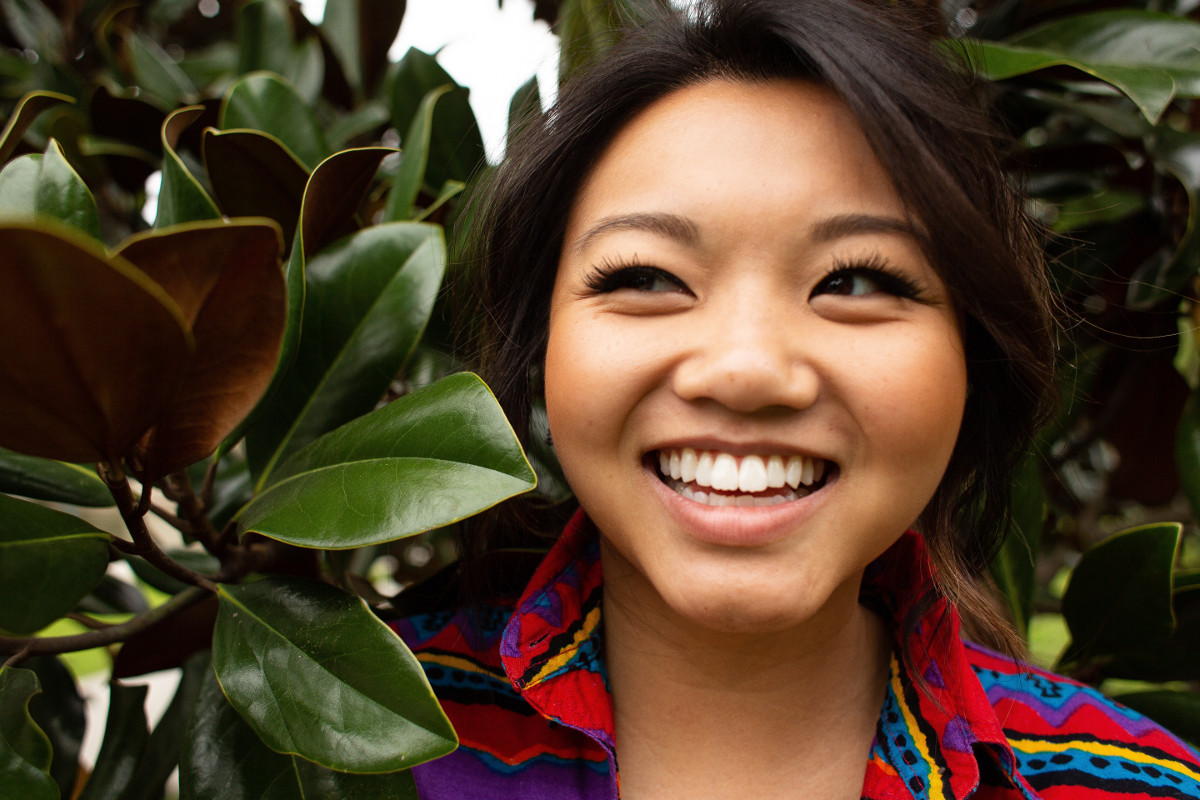 Happy woman among trees. Photographed by Courtney Cook. Image via Unsplash