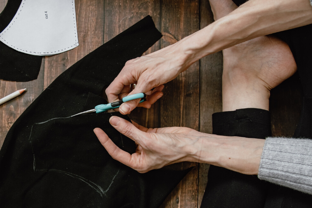 Woman sewing fabric. Photo by Kelly Sikkema on Unsplash