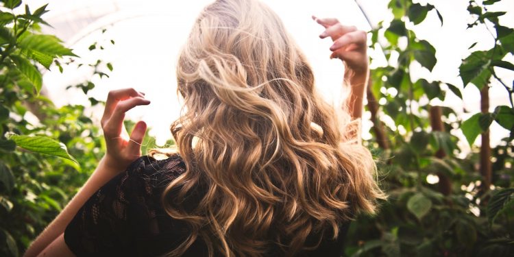 Blonde haired woman in garden. Hair. Photographed by Tim Mossholder. Image via Unsplash
