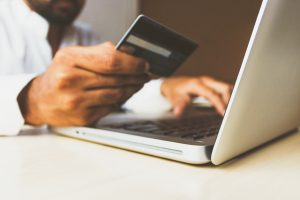 Man uses credit card online. Image by Rubinpix dot com via Unsplash