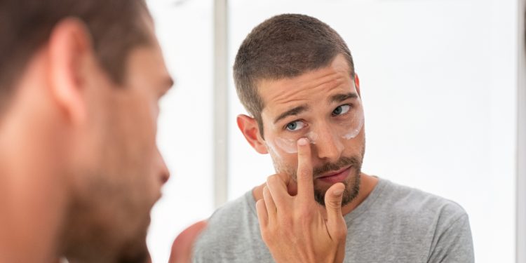 Man applying skincare routine for men