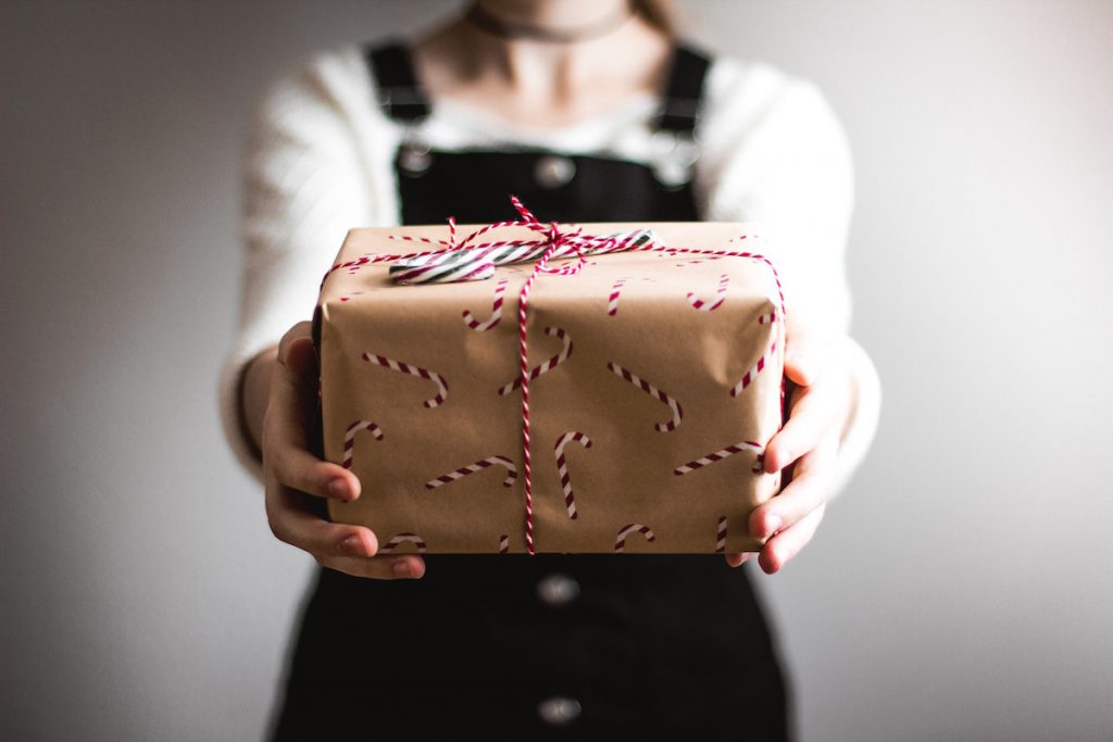 Woman handing over gift. 84% of Hunter and Bligh members prefer giving than receiving gifts. Image by Kira aud fer Heide via Unsplash.