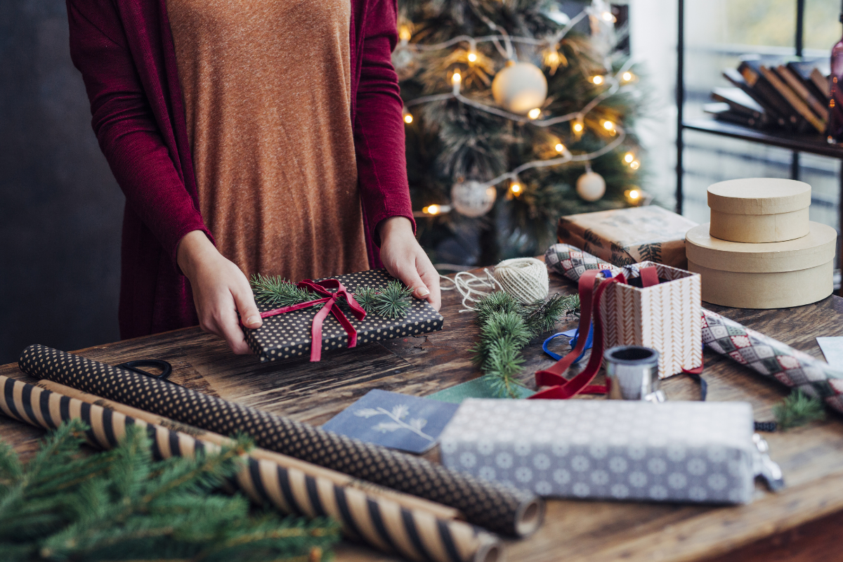 Woman tying ribbon on a gift.