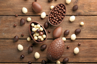Chocolate Easter eggs on a wooden background. Photographed by Africa Studio.