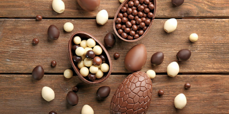 Chocolate Easter eggs on a wooden background. Photographed by Africa Studio.