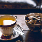 Tea accompanied with a bowl of a sugar cubes. Photographed by John Tecuceanu. Image via Unsplash