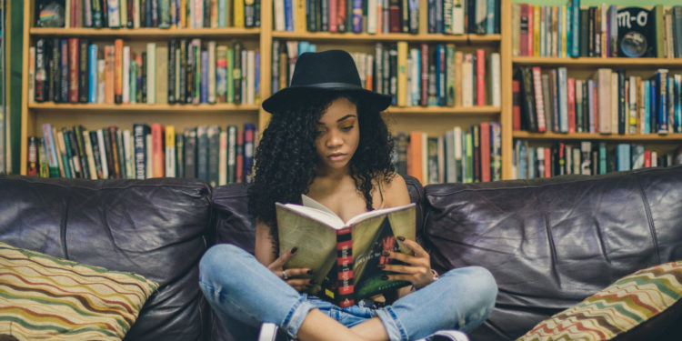 Woman reading book, short story. Photographed by Seven Shooter. Image via Unsplash