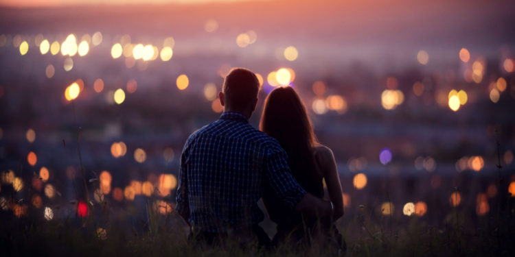 Couple staring at city. Photography by Parilov. Image via Shutterstock