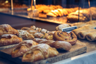 Pastries in a bakery window. Photography by ampersandphoto. Image via Shutterstock.