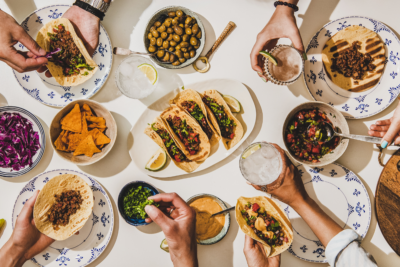 People sharing Mexican food. Photography by Foxys Forest Manufacture. Image via Shutterstock