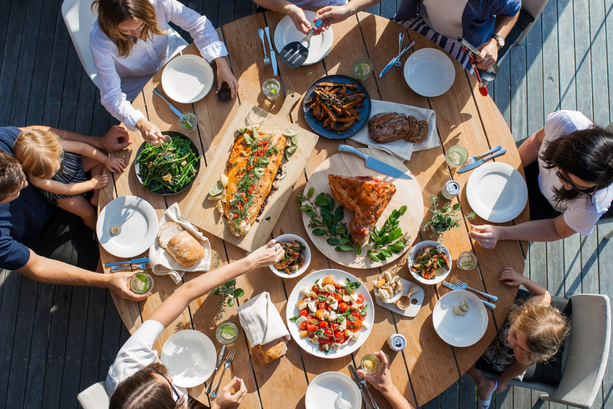 Group of people eating food. Photography by Luisa Brimble. Image via Unsplash