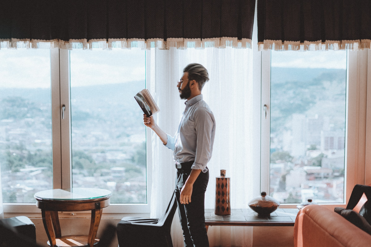 Man reading in living room. Photography by Felipe Bustillo. Image via Unsplash