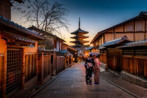 Two women walking through Gion. Photography by Sorasak. Image via Unsplash