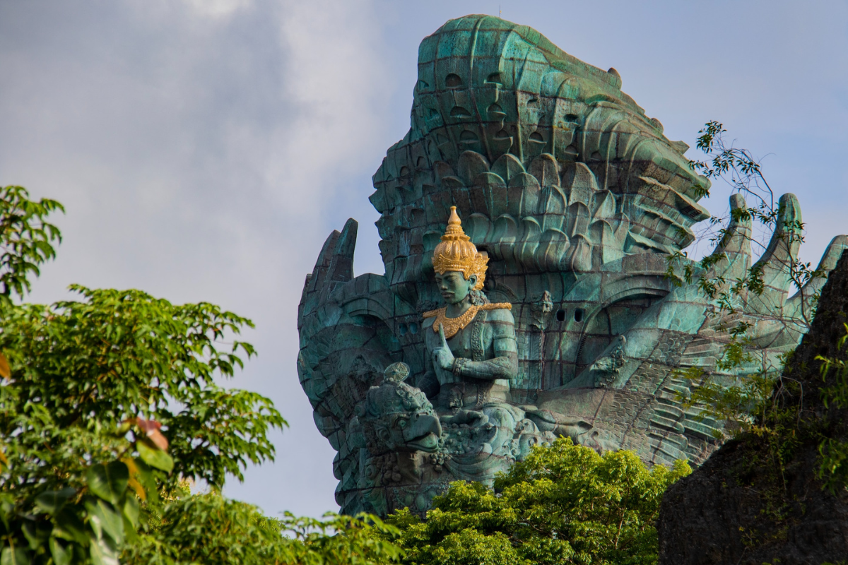 Buddha statues near trees. Photography by Nick Fewings. Image via Unsplash