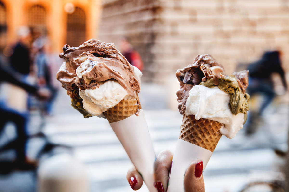 Gelato ice cream cone held up to the hot summer. Photography by Melnyk Sergio. Image via Shutterstock
