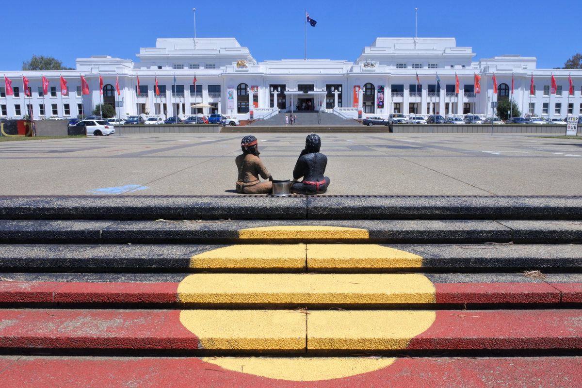 Two Indigenous Australians sitting in Canberra Parliamentary Zone. Photography by ChameleonsEye. Image via Shutterstock