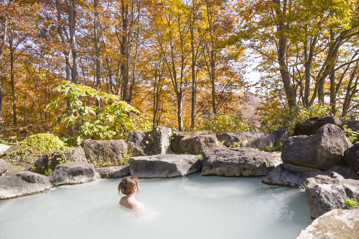 Woman in hot spring. Photography by onemu. Image via Shutterstock