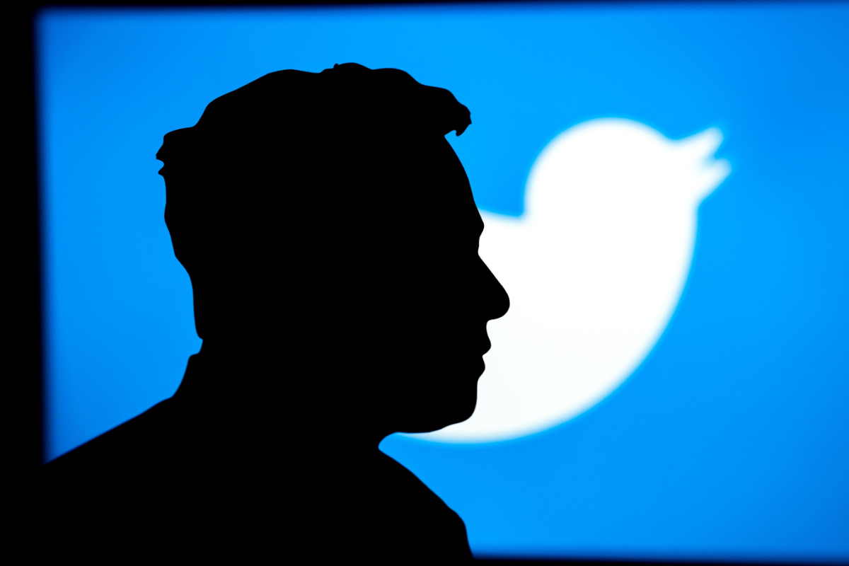 Profile of Elon Musk against the backdrop of Twitter logo. Photography by kovop. Image via Shutterstock