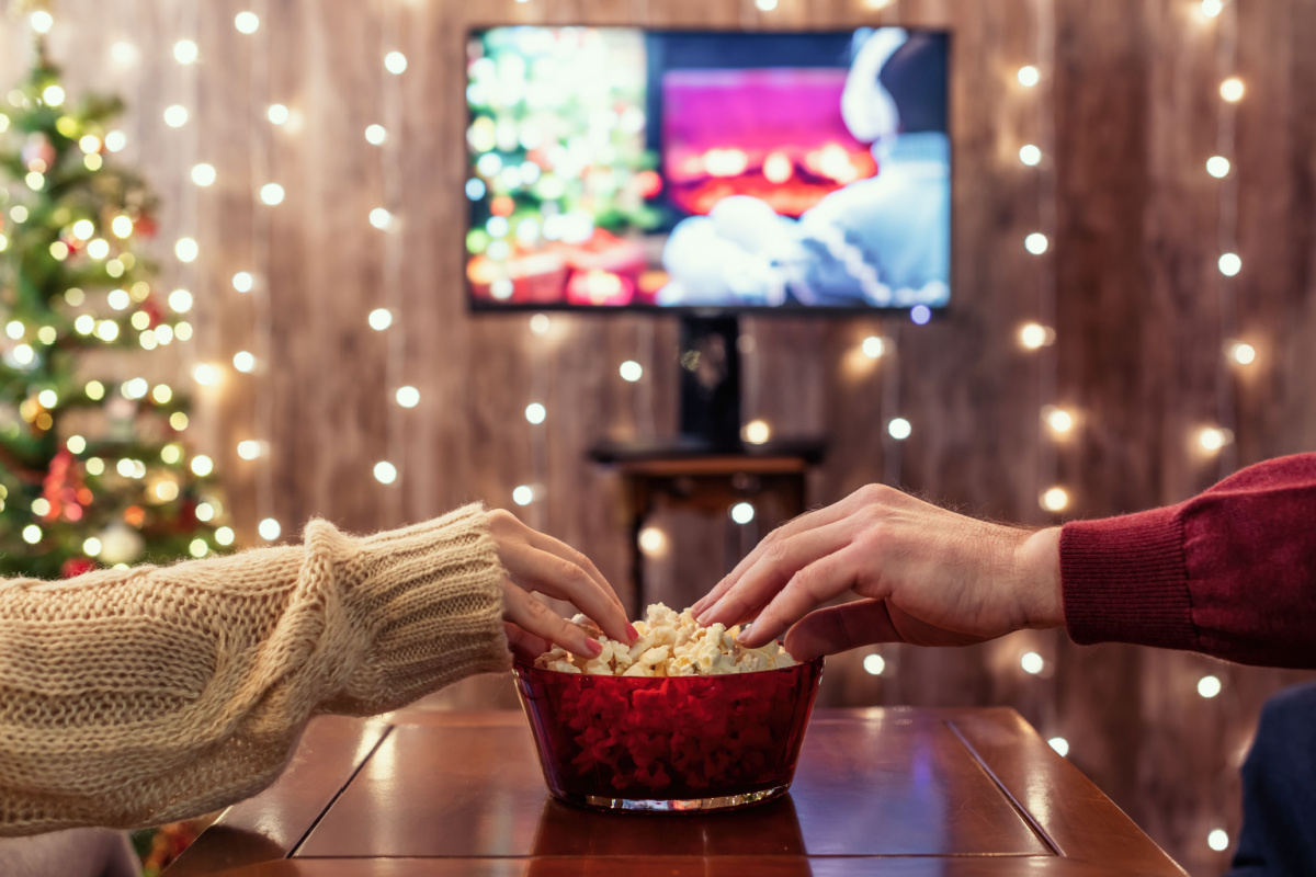 A couple watching a movie on Christmas. Photography by FTiare. Image via Shutterstock