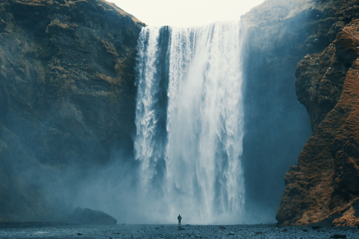 Person looking at waterfall. Photography by likingthings. Image via Shutterstock