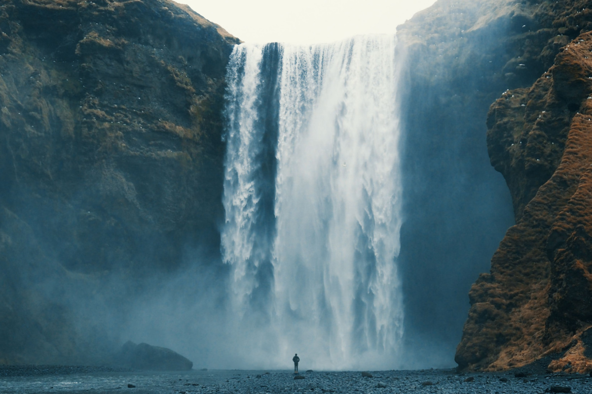 Person looking at waterfall. Photography by likingthings. Image via Shutterstock