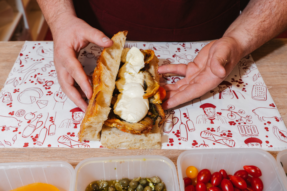 Opening up a sandwich at UGO Burrata Bar. Image supplied