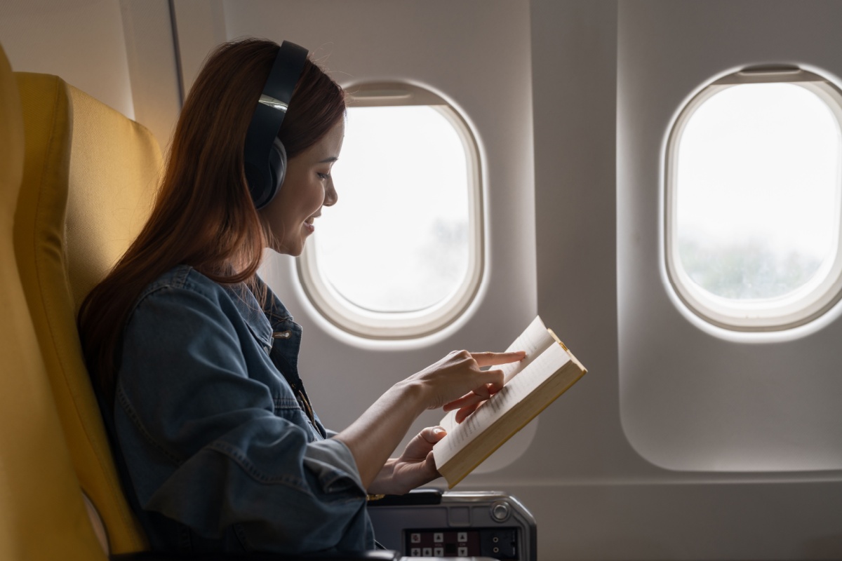 Traveller reading book. Photography by Natee Meepian. Image via Shutterstock