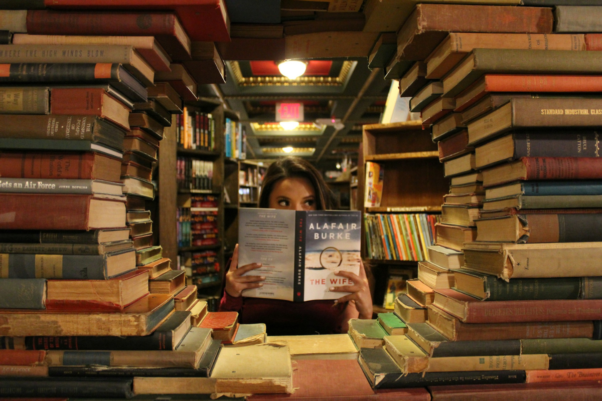 Woman holding book. Photography by setbydaniel. Image via Unsplash